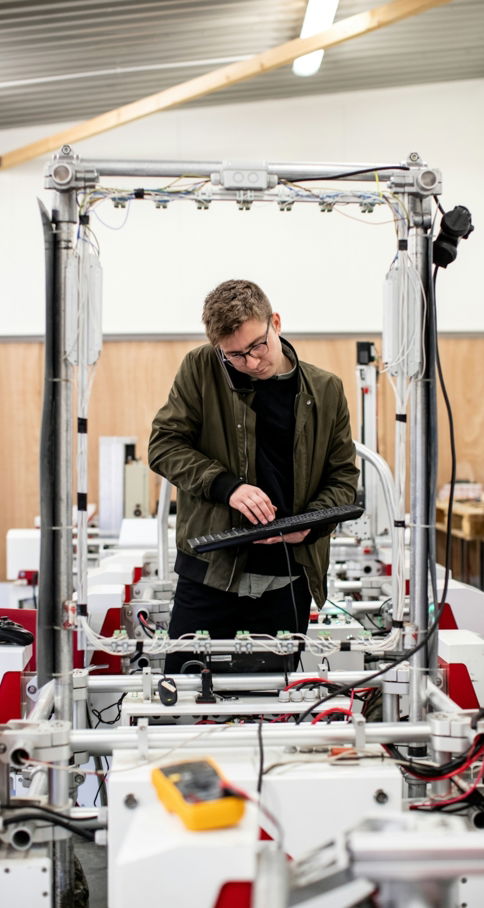 man in brown jacket using a machine